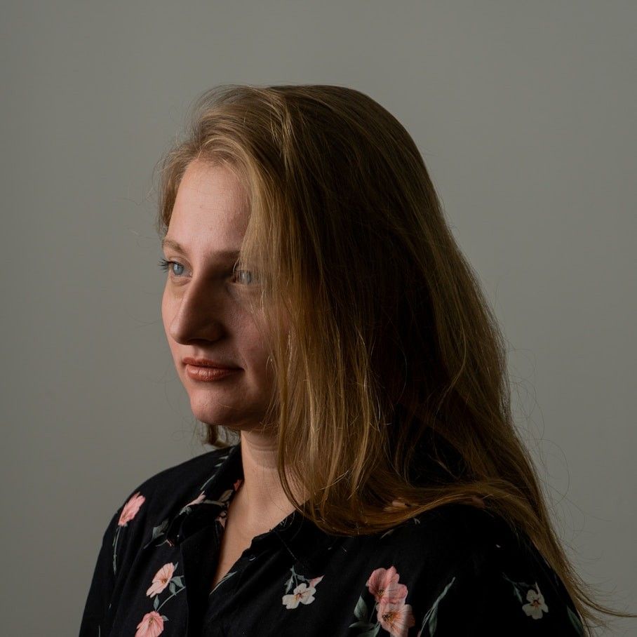 Portrait of Claire Donovan in a dark floral blouse, looking to the side